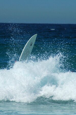 big wave, white foam, surfboard wihtout a surfer, action