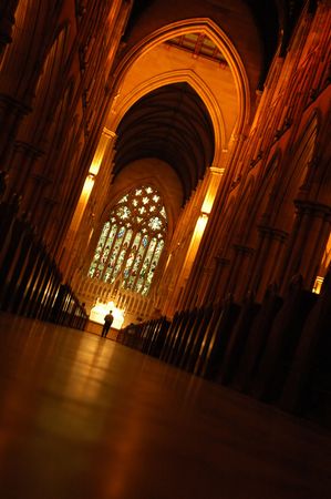 church interior, high ceiling, red lights, solitary man standing in front of altarのeditorial素材