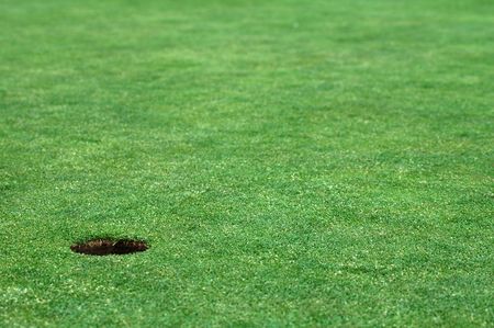 short cutted grass, golf hole, no ball, distance blurの写真素材