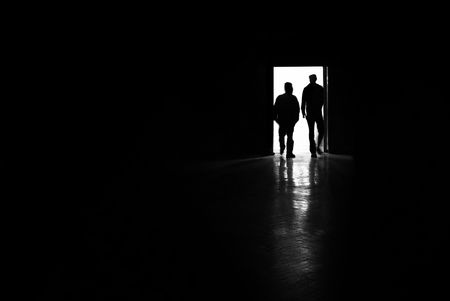 two man silhouettes entering a room, black and white photoの写真素材