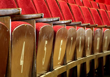 red wooden seats in theatre, numbers on seatsの写真素材