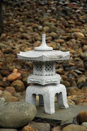 small buddhist sculpture made of stone, small stones in backgroundの写真素材