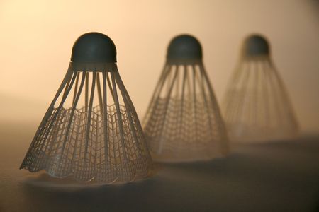 three badminton shuttlecocks on brown background, distance blurの写真素材