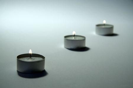 three small candles on white background, distance blurの写真素材