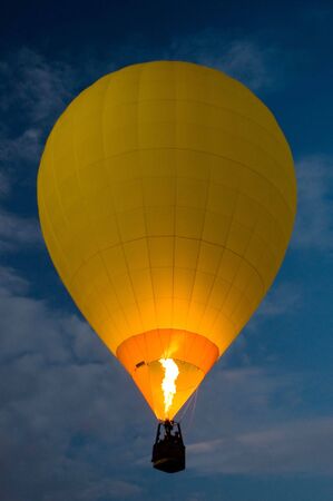 yellow balloon flying at night, dark blue sky,の写真素材