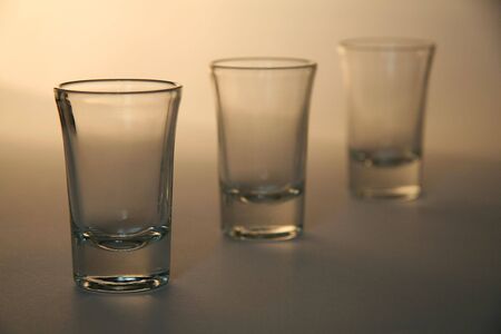 three liquor glasses, simple brown background, distance blurの写真素材