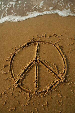 peace sign on a beach, in a moment water will wash it away, dusk photoの写真素材