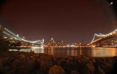 brooklyn and manhattan bridge night photo, rocks in foreground, star filter used to bring up the...