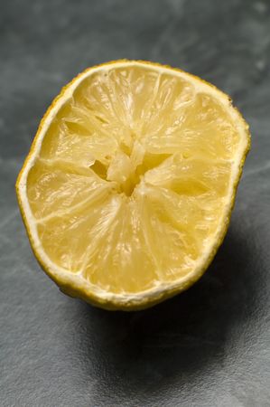 squeezed out lemon on green marble like desk