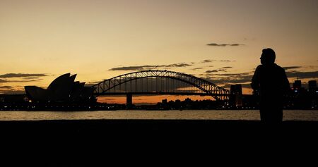 opera house, harbor bridge and a man silhouettes, dusk photo, Sydney, Australiaの写真素材