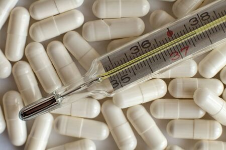 medical thermometer on white pills, high temperatureの写真素材