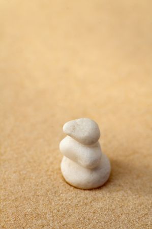 three small white stones on a sand, vertical photo, shallow depth of viewの写真素材