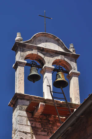 two small historic bells on a typical Croatian churchの写真素材