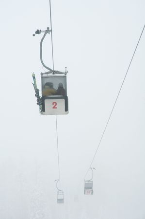 vertical photo of cableways in thick fog