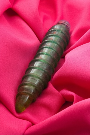 latex dildo on pink fabric background, vertical photoの写真素材