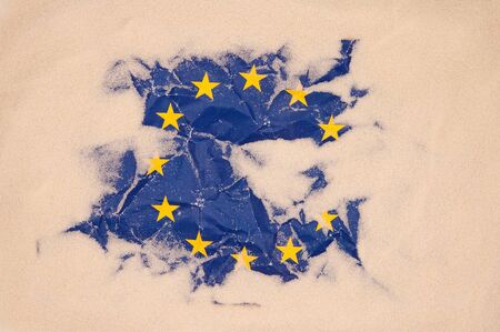 damage European Union flag buried in sand  conceptual photoの写真素材