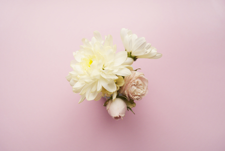 Bouquet of white chrysanthemums and cream roses on a pink background. Flat layの写真素材