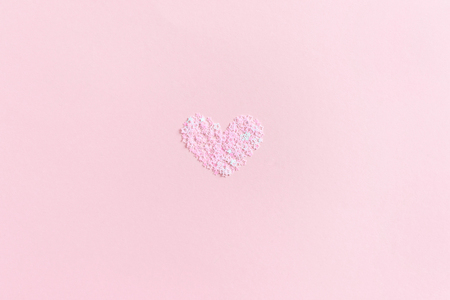 Heart made from star sequins on a pink pastel backgroundの写真素材