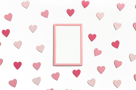 Photo frame mock up. Pattern made of colorful hearts on a white backgroundの写真素材