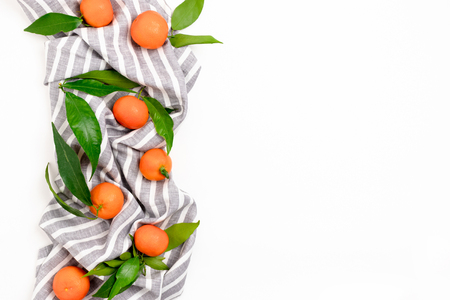 Border frame made of mandarins on a striped linen towel on a white backgroundの写真素材