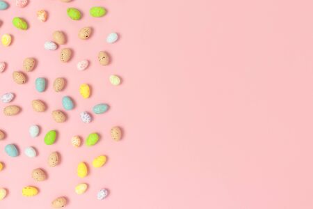 Frame made of colorful easter eggs on a pink pastel background. Holiday creative concept with place...