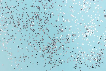 Texture made of shiny silver stars on blue pastel background. Holiday backdrop.の写真素材