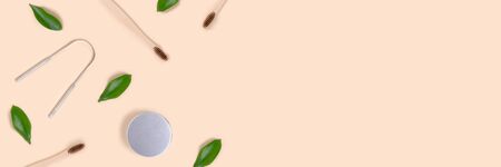 Banner with frame made of accessories for tooth hygiene and green leaves on a beige background. Plastic free concept with copy space.の写真素材