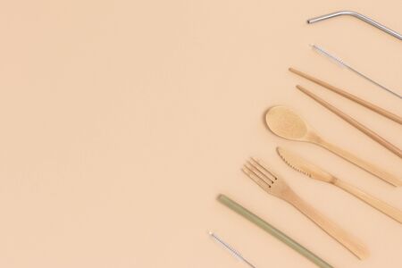 Frame made of bamboo cutlery on a beige background. Zero waste concept with copy space.