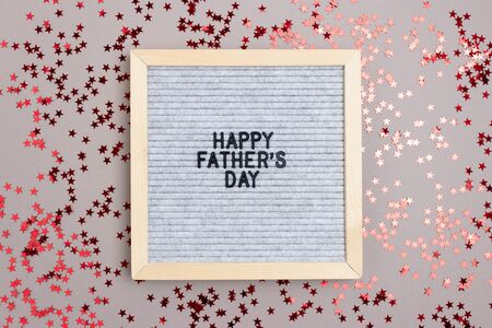 Letterboard with quote Happy fathers day on gray background. Holiday concept with red stars...