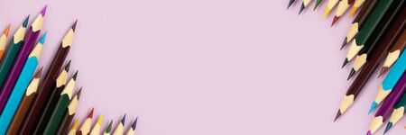 Top view of colorful pencils on a purple pastel background. Back to school concept with copy space.の写真素材