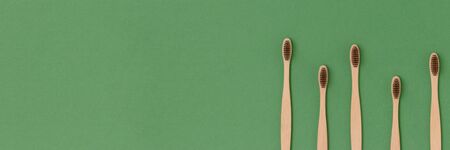 Frame made of toothbrushes on a green background. Plastic free banner with place for text.の写真素材
