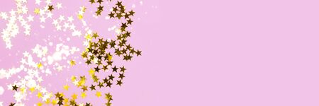 Golden stars confetti texture on a purple pastel background. Festive shiny banner with place for text.の写真素材