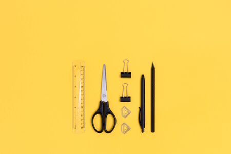 Group of black office supplies on a beige background. Creative layout.の写真素材