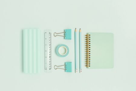 Set of office supplies on a mint pastel background. Monochrome creative concept.