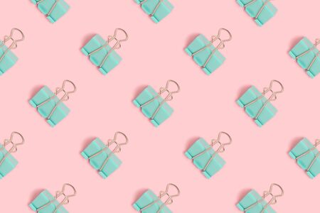 Mint paper clips pattern on a pink pastel background. School supplies layout.の写真素材