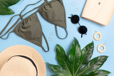 Summer flat lay on blue background. Composition with green leaves, women's clothes and accessories.の写真素材