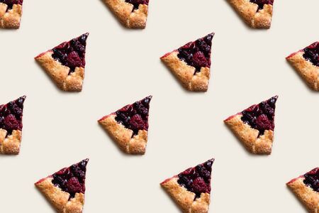Pieces of homemade berry cake pattern on a beige background.の写真素材