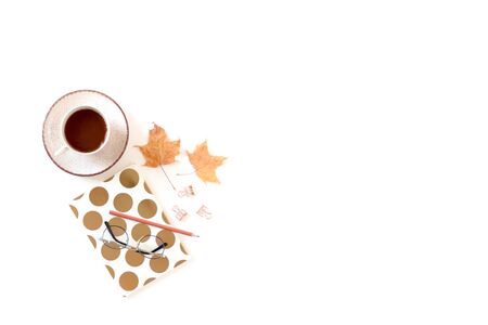 White desk with mug of coffee, notebook, glasses, dried maple leaves. Autumn composition with copy space.の写真素材