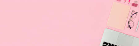 Banner with laptop, glasses, notepad and stationery on a pink pastel background. E-learning...