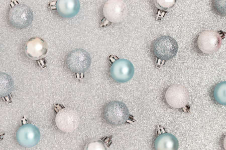 Pattern made of Christmas baubles on a silver textured background. Shiny festive concept.の写真素材
