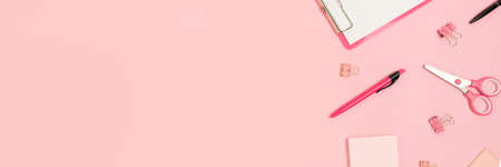 Banner with scattered office supplies on a pink background. Back to school composition.