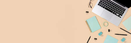 Online education concept with laptop and stationery on a beige background. Creative banner.の写真素材