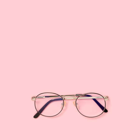 Eyeglasses on a pink pastel background. Minimalistic concept with place for text.の写真素材