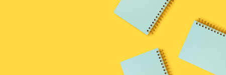 Banner with mint spiral notebooks on a yellow background. Cute school supplies.の写真素材