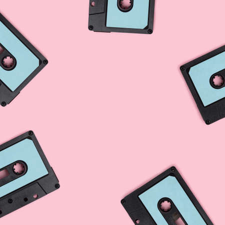 Wreath made of cassette tapes on a pink background. Creative template with place for text.