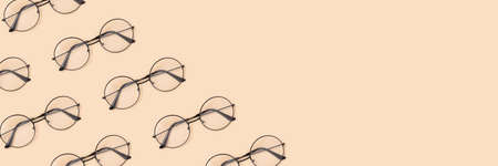 Frame made of round vintage eyeglasses pattern on a beige background. Banner template for your design.の写真素材