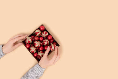 Woman's hand takes a Christmas ball from the box. Creative festive concept with copy space.の写真素材