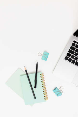 Top view of workspace with laptop and stationery on a white table. Minimalistic concept with place for text.の写真素材