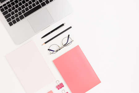 Office layout with laptop, glasses and stationery. White table with empty space.の写真素材