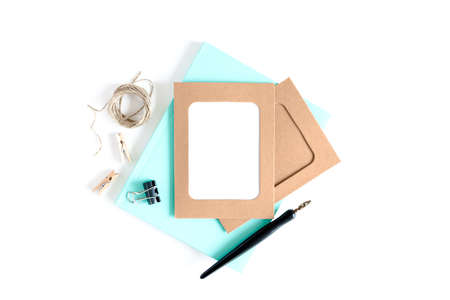 Stylish minimal composition with kraft paper frame, wooden clothespins, twine, calligraphic pen,...